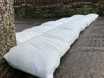 Eine Barriere aus Floodsax Säcken als Hochwasserschutz