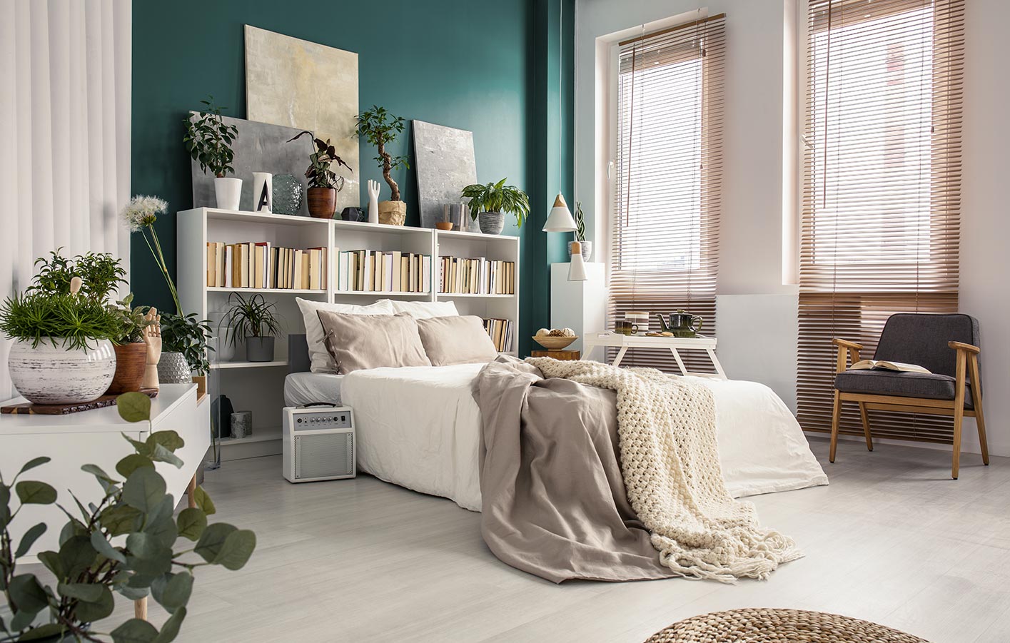 heller Laminatboden in einem Schlafzimmer mit hellen Möbeln und Grünpflanzen
